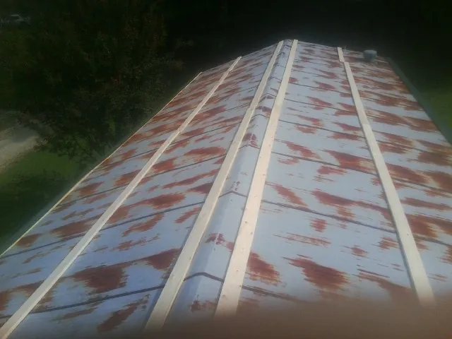 Rusted metal roof panels with new wood purlins before replacement — Storm Damage Roof Repair in Brecksville by Roofing Brothers