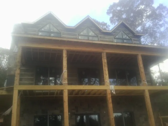 Dormers and porch framing on a large log home under construction — Roof Coating work by our crew in Brecksville
