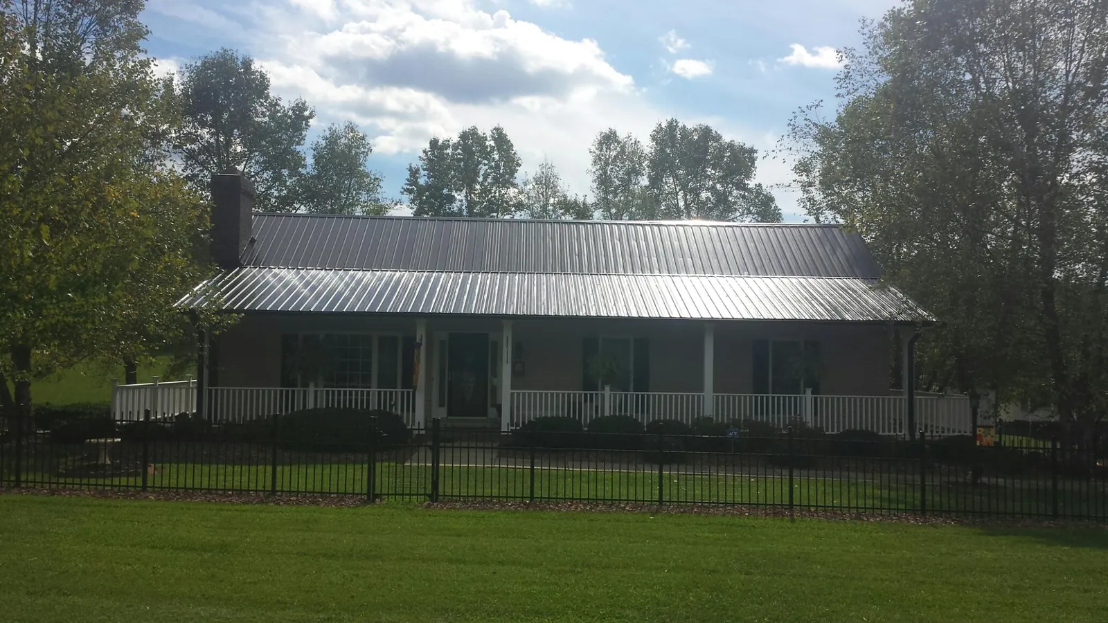 Gray metal roof on a brick ranch with a full width front porch — Gutter Guard Installation work by our crew in Brecksville