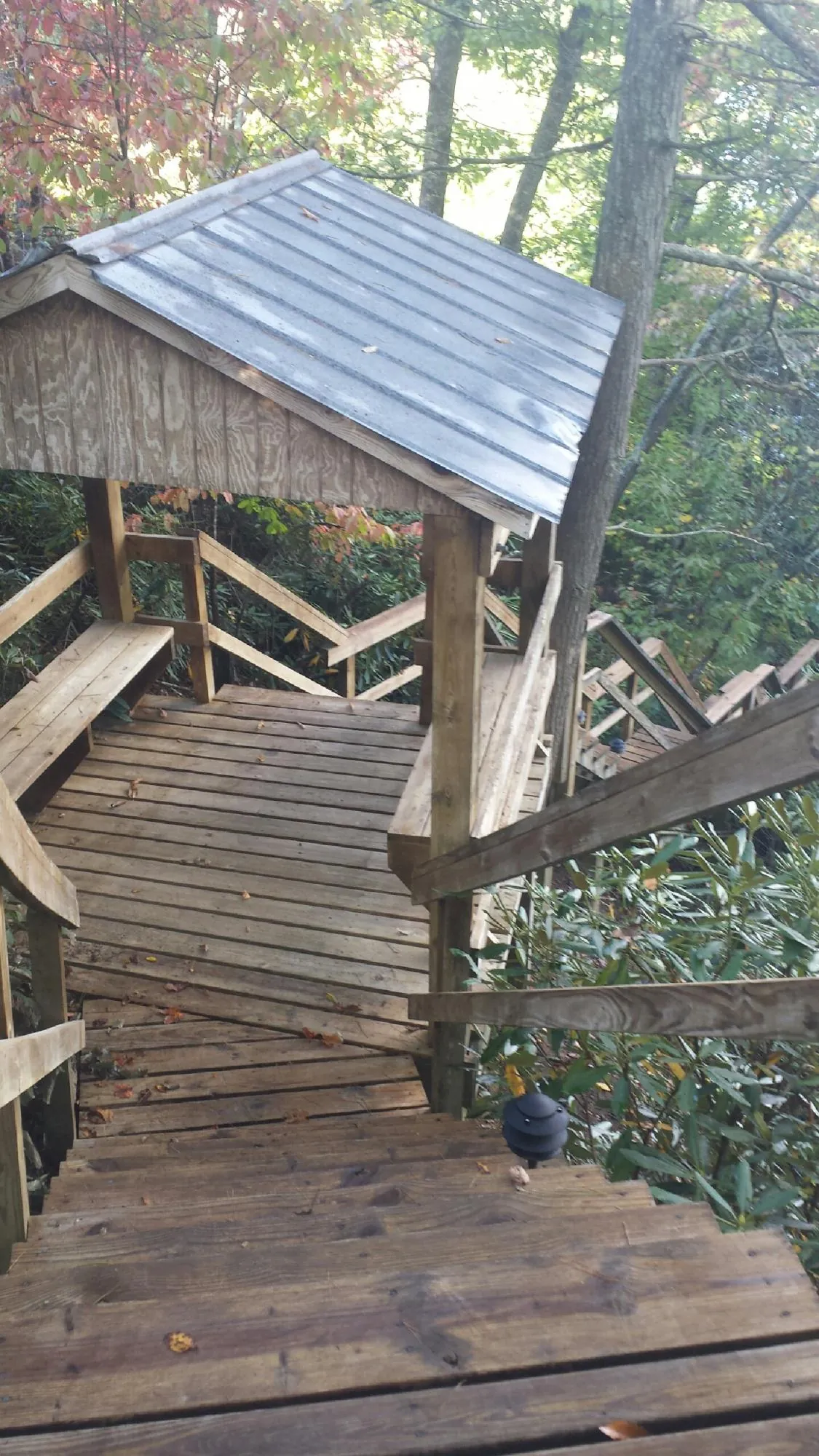 Metal roofed shelter over wooden steps on a wooded walkway — Skylight Repair & Installation work by our crew in Brecksville
